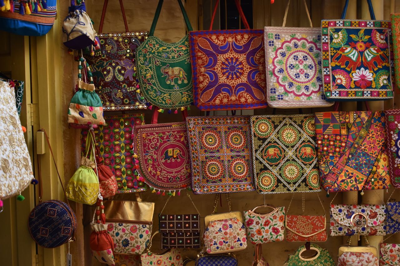 about-us-02 A vibrant collection of traditional embroidered handbags showcasing intricate patterns.